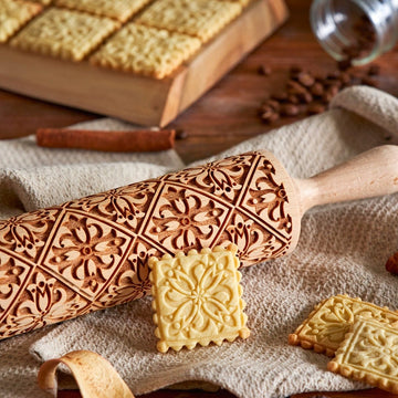 Mosaic pattern engraved on a wooden embossed rolling pin, beside the shortbread cookies it prints
