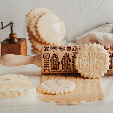 Scandinavian Life pattern engraved on a wooden embossed rolling pin, beside the cookies it prints