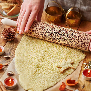 Snowy Winter pattern engraved on a wooden embossed rolling pin, beside the shortbread cookies it prints