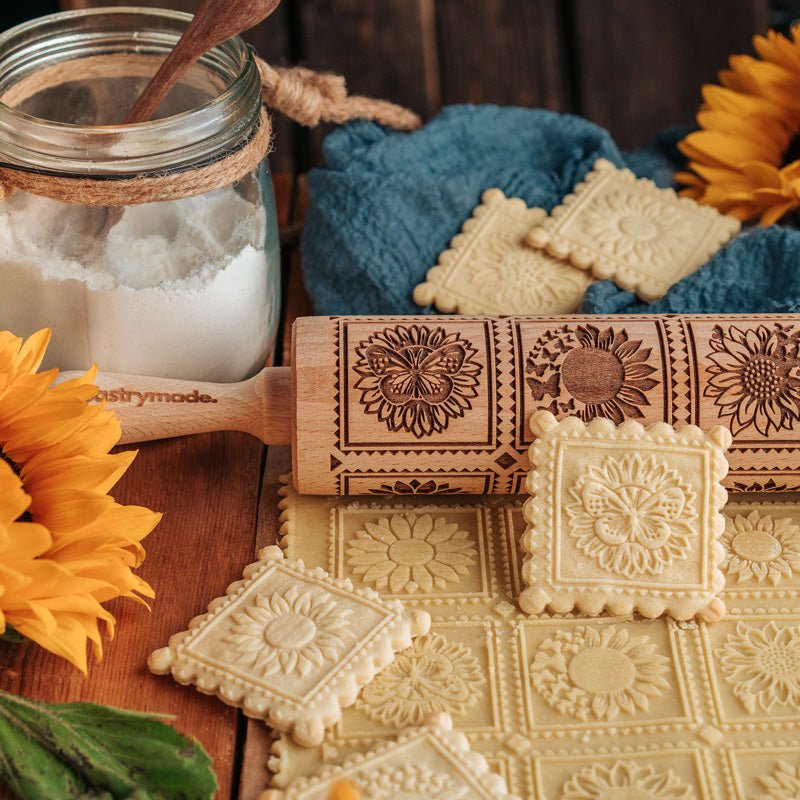 Cookies with a clear sunflower pattern next to a Pastrymade rolling pin