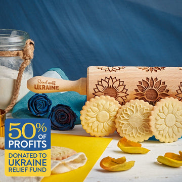 Stand With Ukraine pattern engraved on a wooden embossed rolling pin, beside the cookies it prints