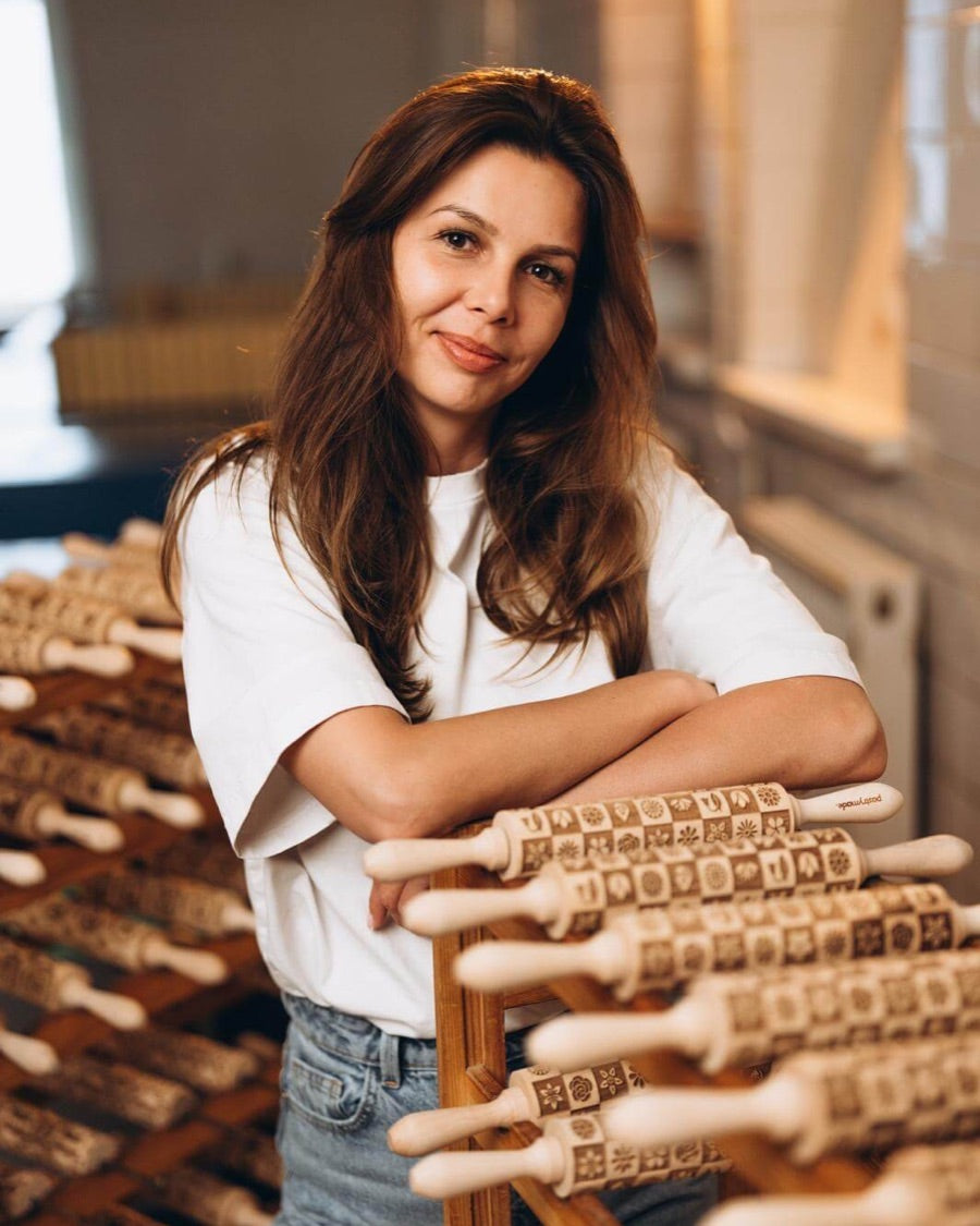 Karolina, founder of Pastrymade, next to racks of engraved rolling pins